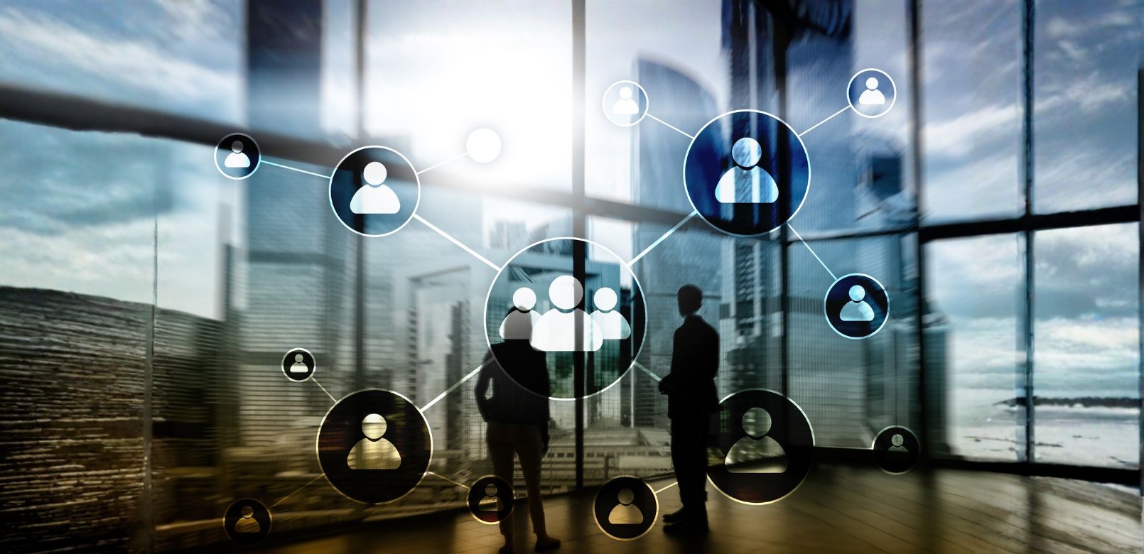 2 אנשים מסתכלים במשרד מסתכלים לעבר החלון שמשקיף לנוף עם בניינים
